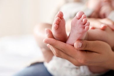 Photo of Mother with her cute little baby at home, closeup. Space for text