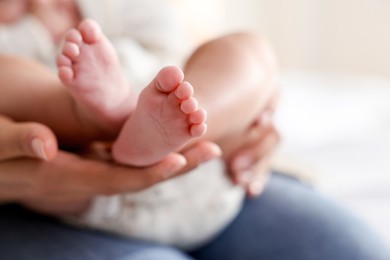 Photo of Mother with her cute little baby at home, closeup. Space for text