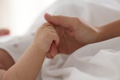 Photo of Mother with her sleeping little baby on bed at home, closeup