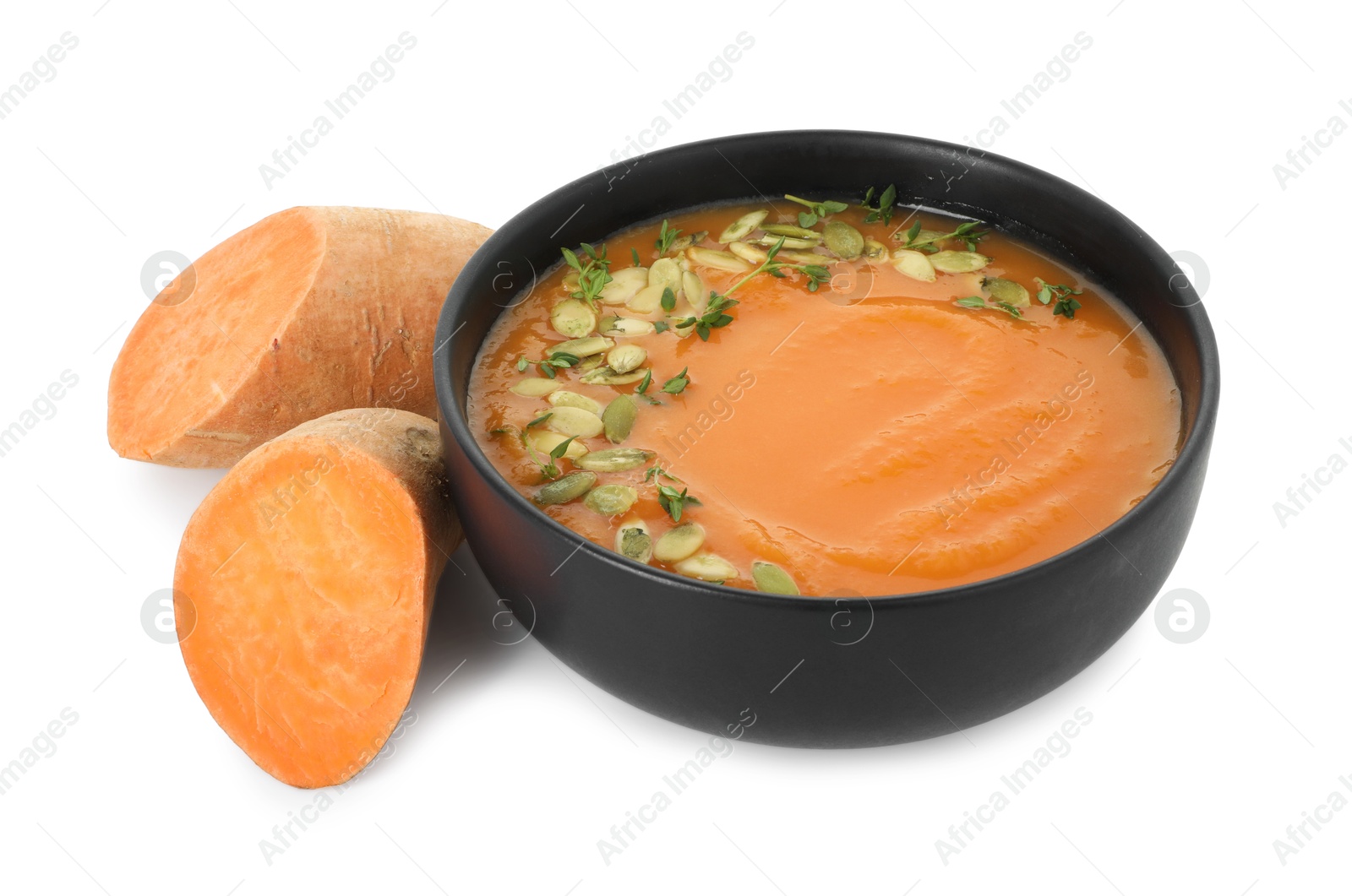 Photo of Delicious sweet potato soup with pumpkin seeds in bowl and fresh vegetable isolated on white