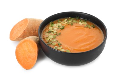 Photo of Delicious sweet potato soup with pumpkin seeds in bowl and fresh vegetable isolated on white