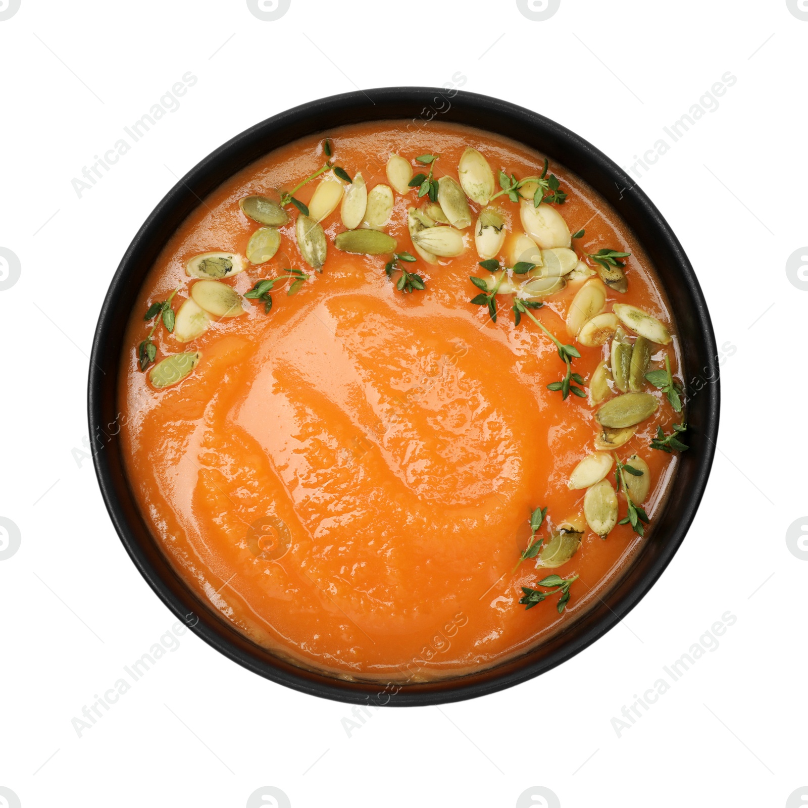 Photo of Delicious sweet potato soup with pumpkin seeds in bowl isolated on white, top view