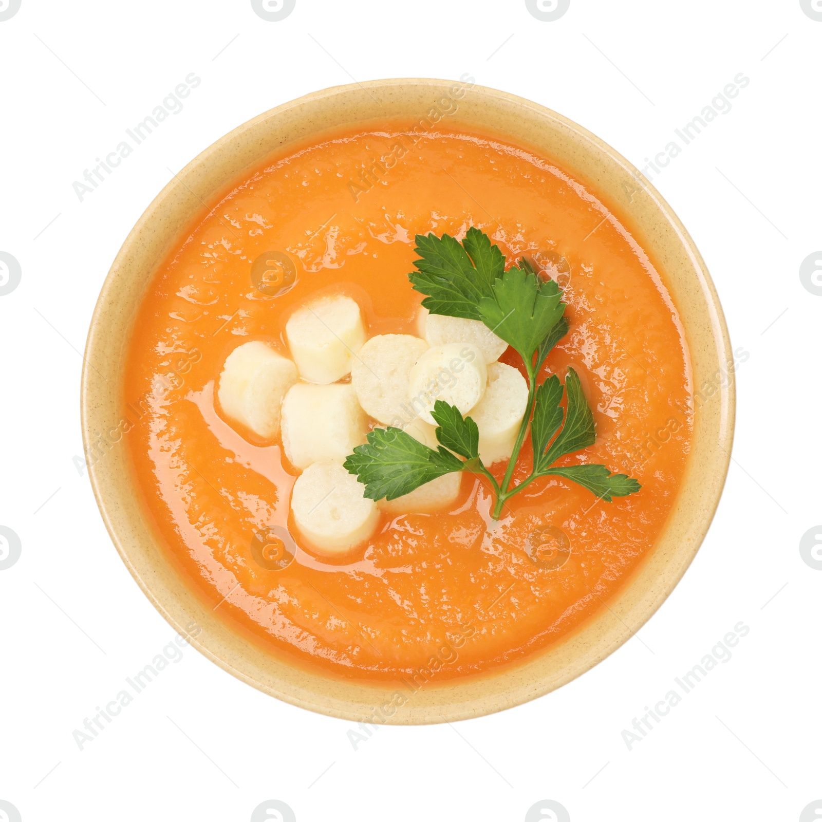 Photo of Delicious sweet potato soup with croutons in bowl isolated on white, top view