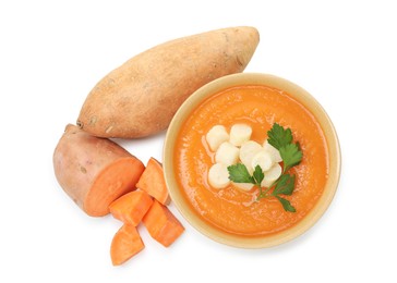 Photo of Delicious sweet potato soup with croutons in bowl and fresh vegetables isolated on white, top view