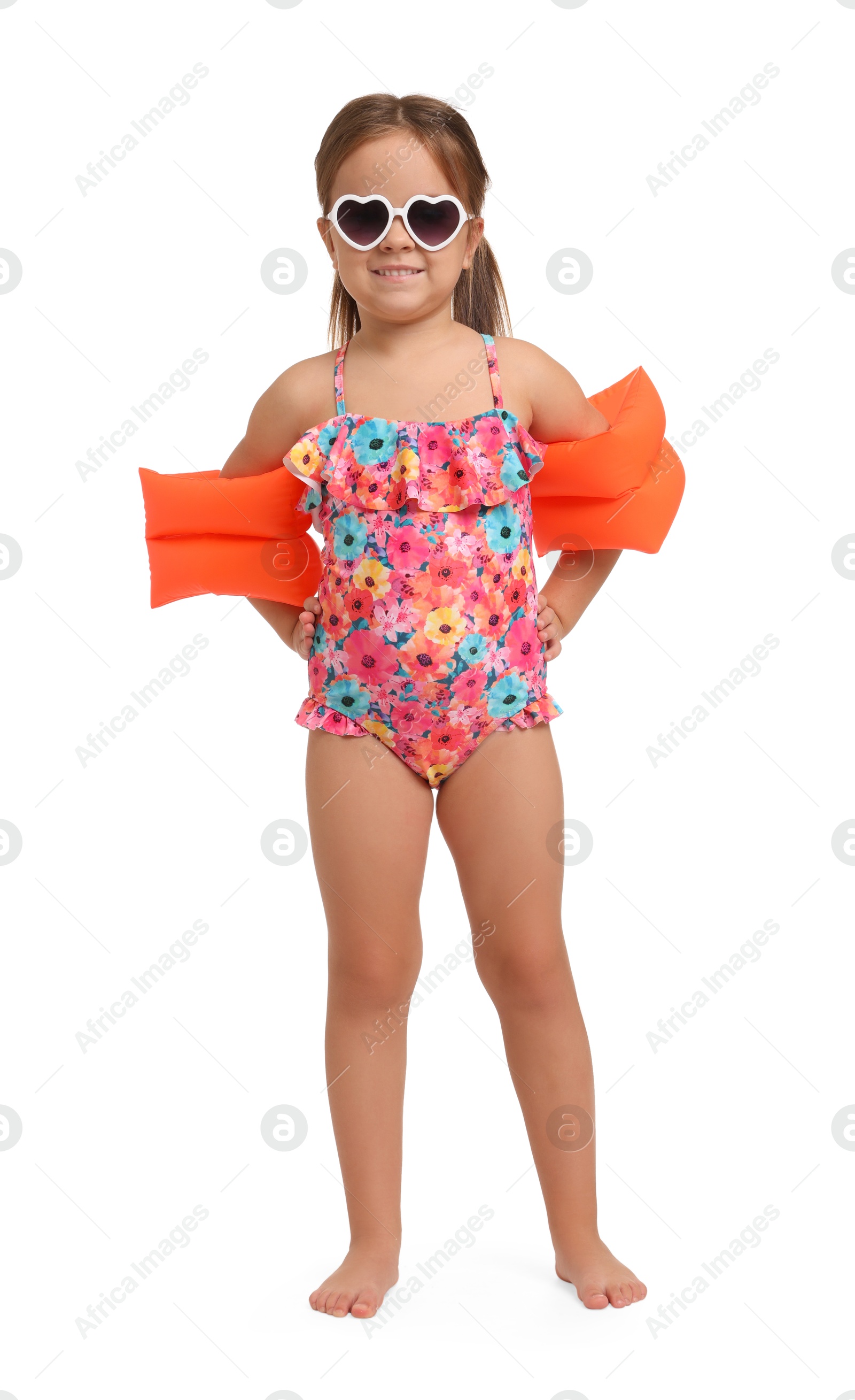 Photo of Cute little girl in swimsuit with swim armbands on white background