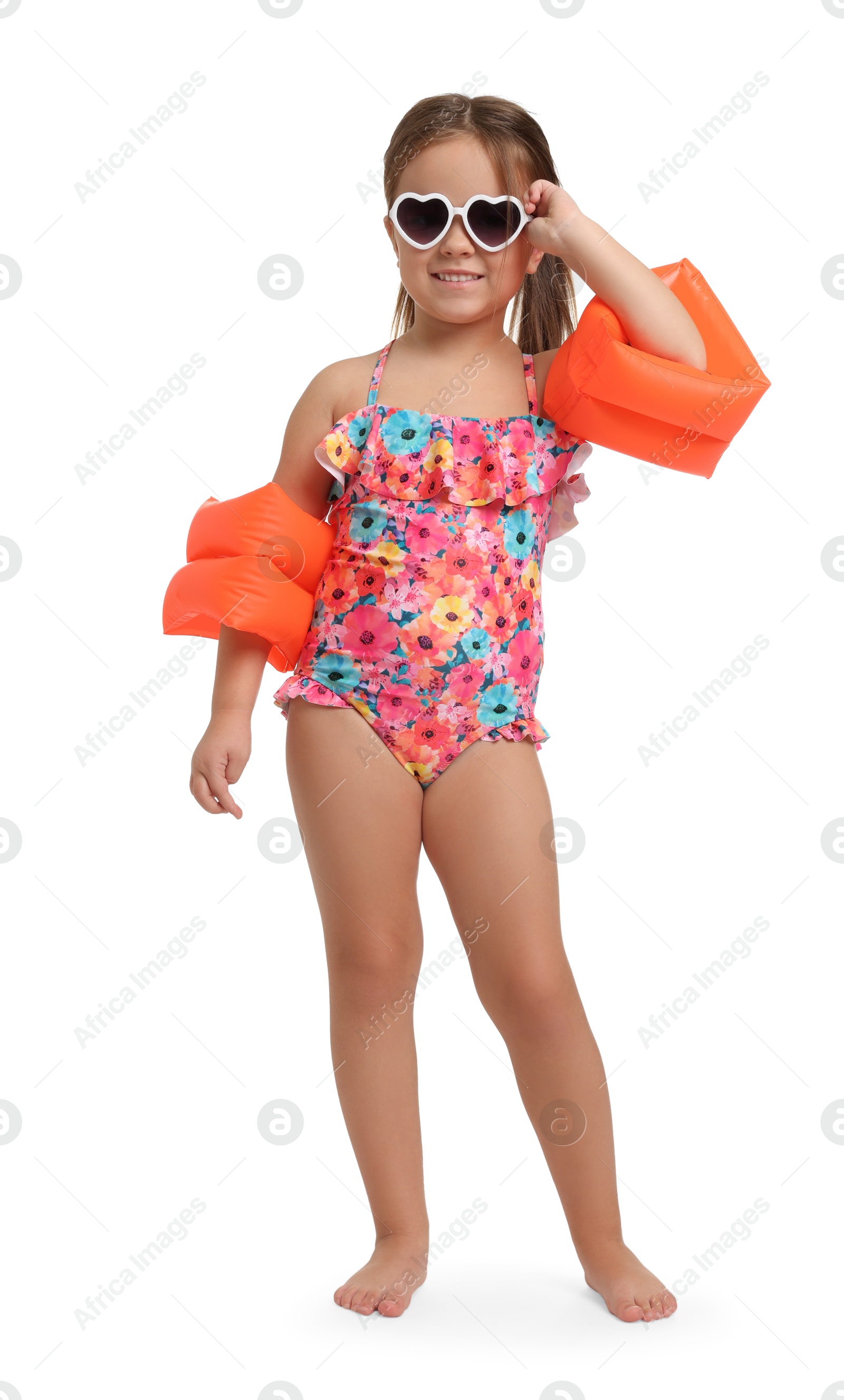 Photo of Cute little girl in swimsuit with swim armbands on white background