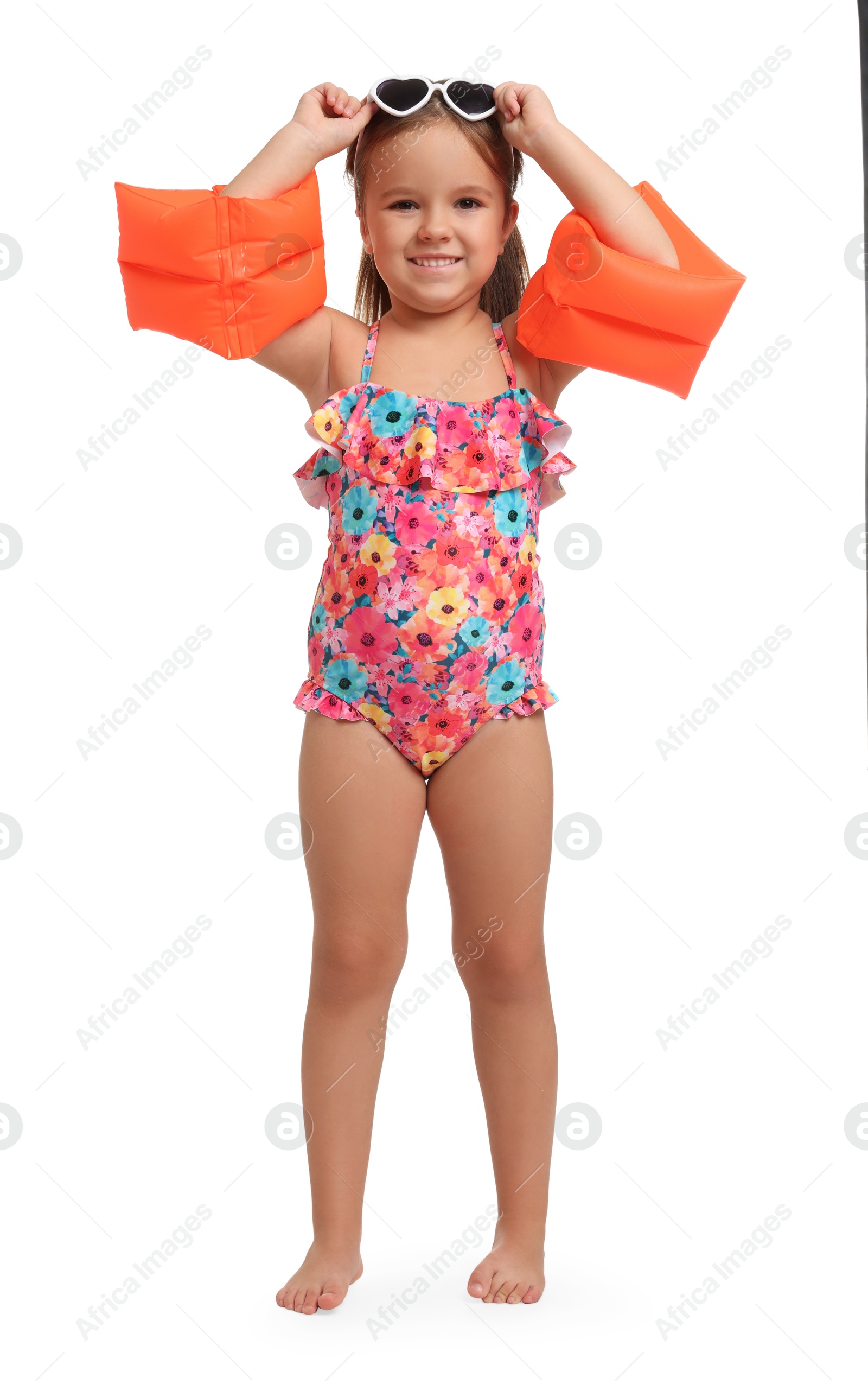 Photo of Cute little girl in swimsuit with swim armbands on white background