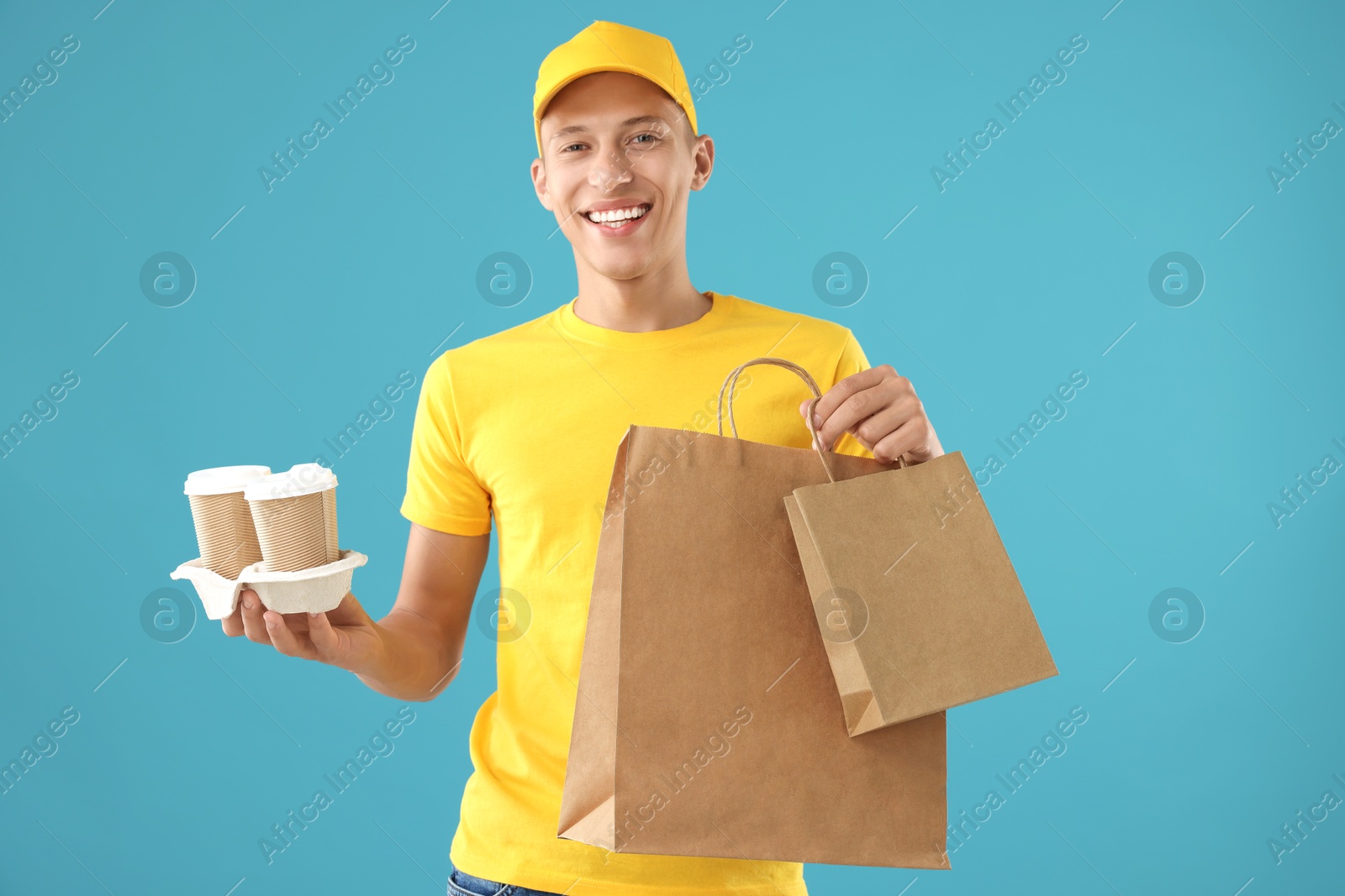 Photo of Fast-food worker with paper bags and cups on light blue background