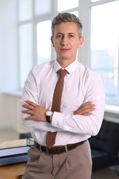 Photo of Portrait of middle aged man with crossed arms in office