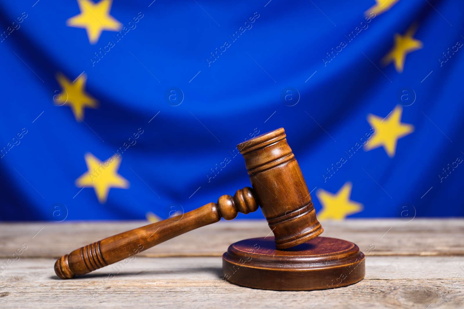 Photo of Judge's gavel on wooden table against European Union flag