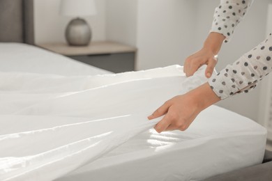 Photo of Woman changing clean bed linens at home, closeup