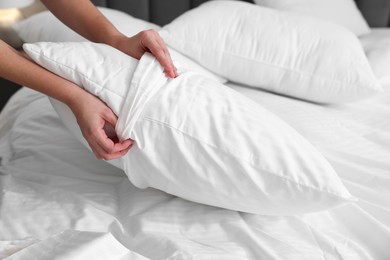 Photo of Woman changing clean bed linens at home, closeup