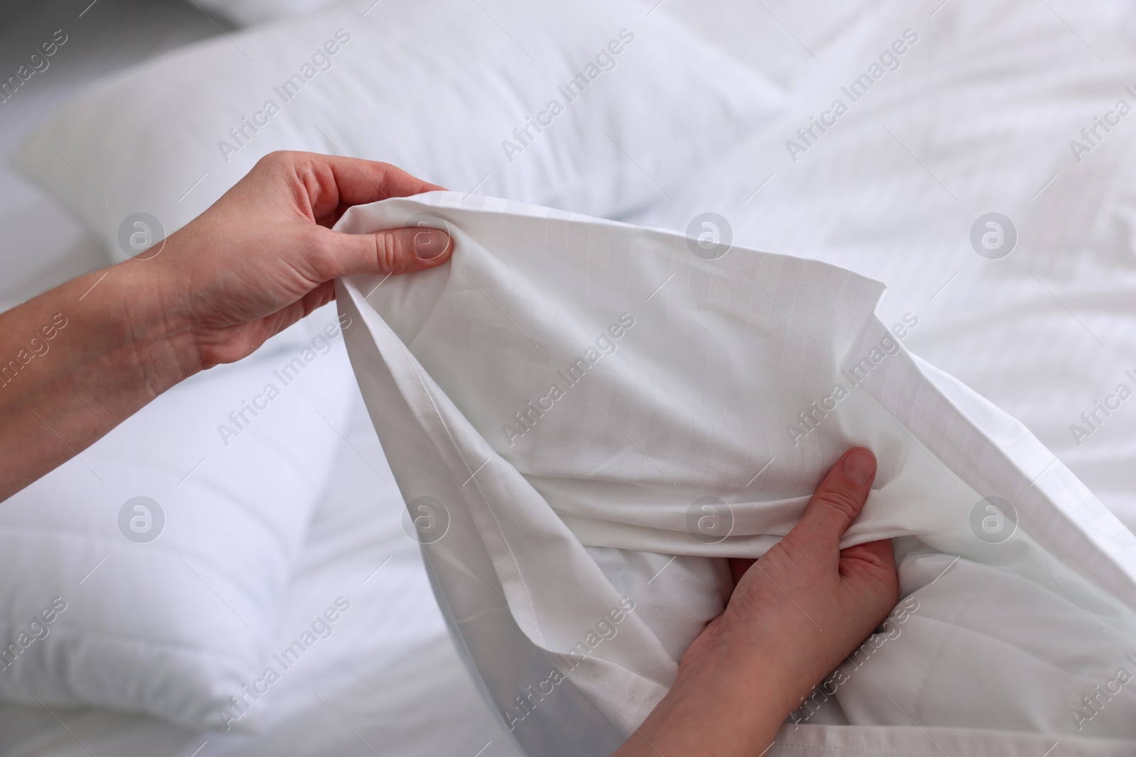 Photo of Woman changing clean bed linens at home, closeup