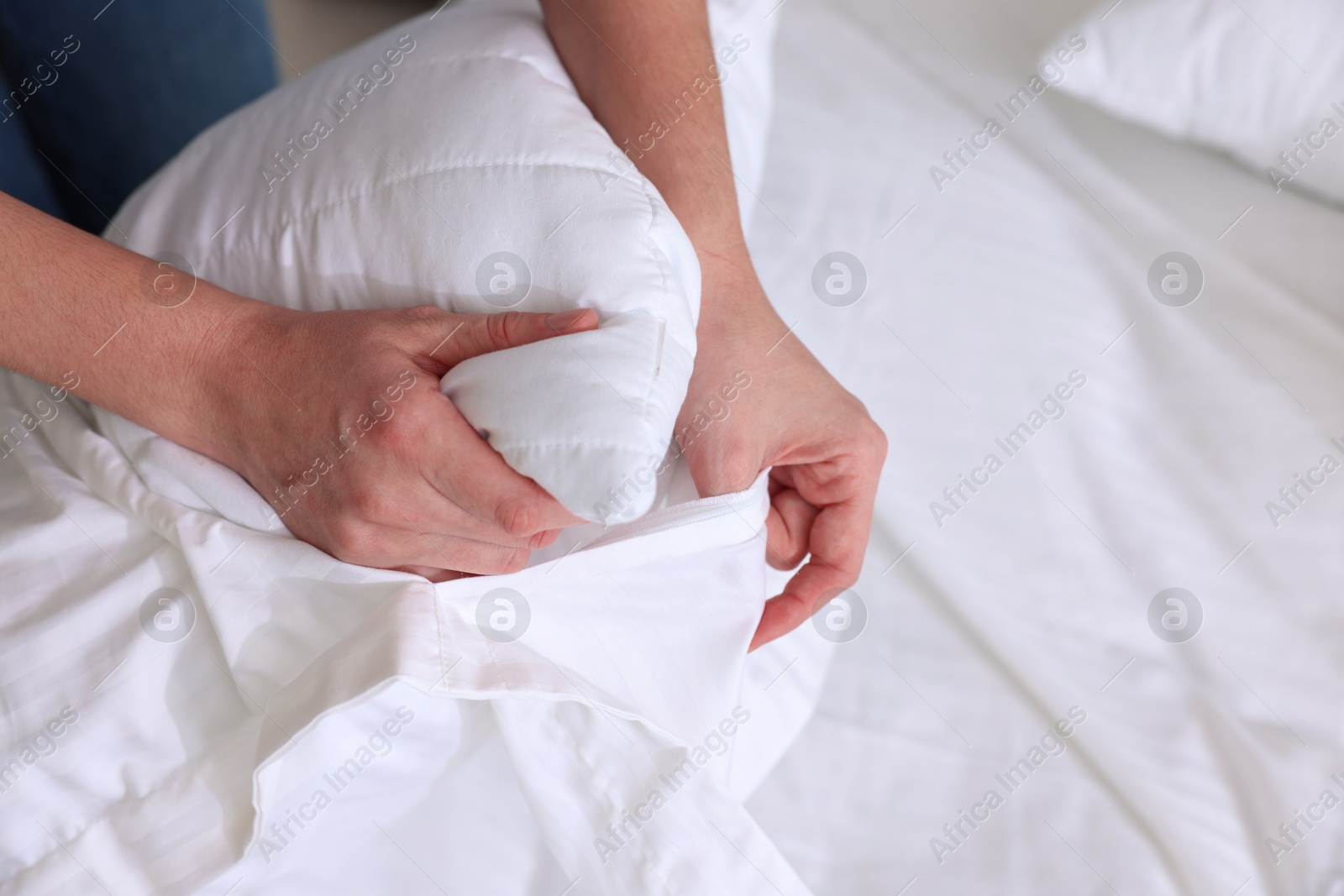 Photo of Woman changing clean bed linens at home, closeup