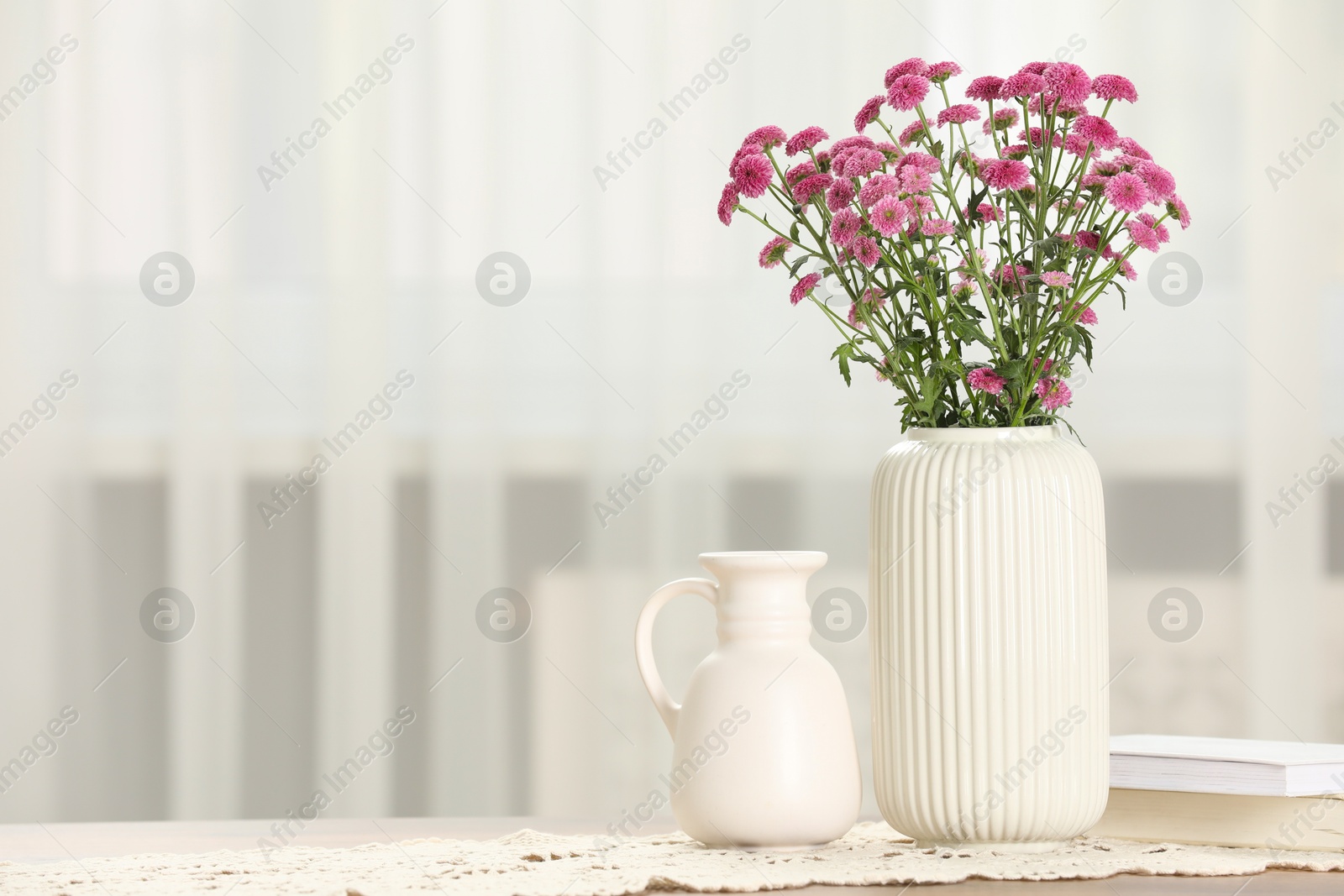 Photo of Beautiful pink flowers in vase on table at home, space for text