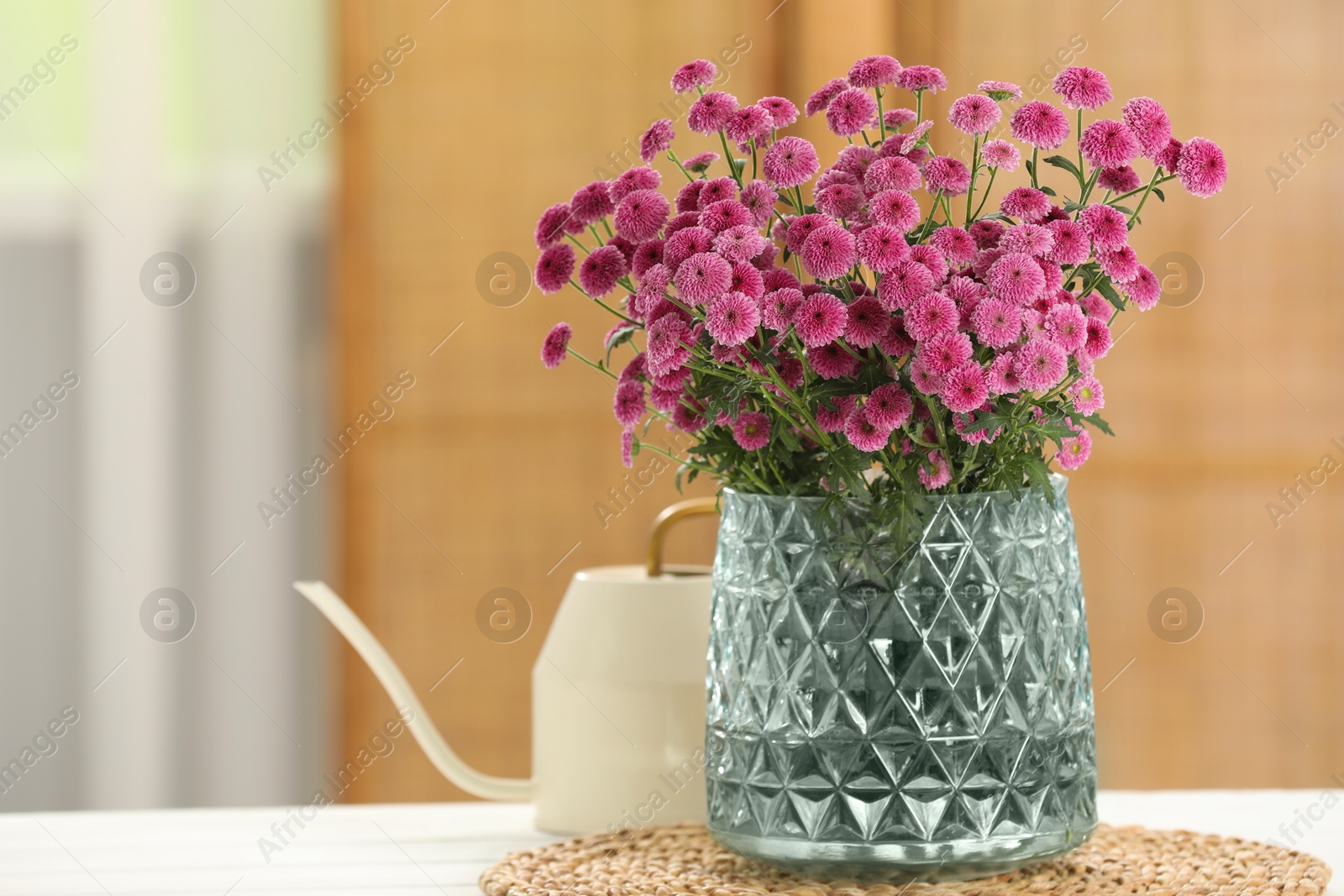 Photo of Beautiful pink flowers in vase on table at home