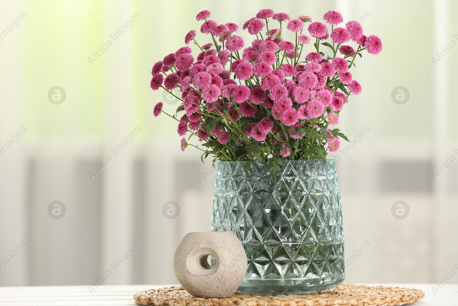 Photo of Beautiful pink flowers in vase on table at home