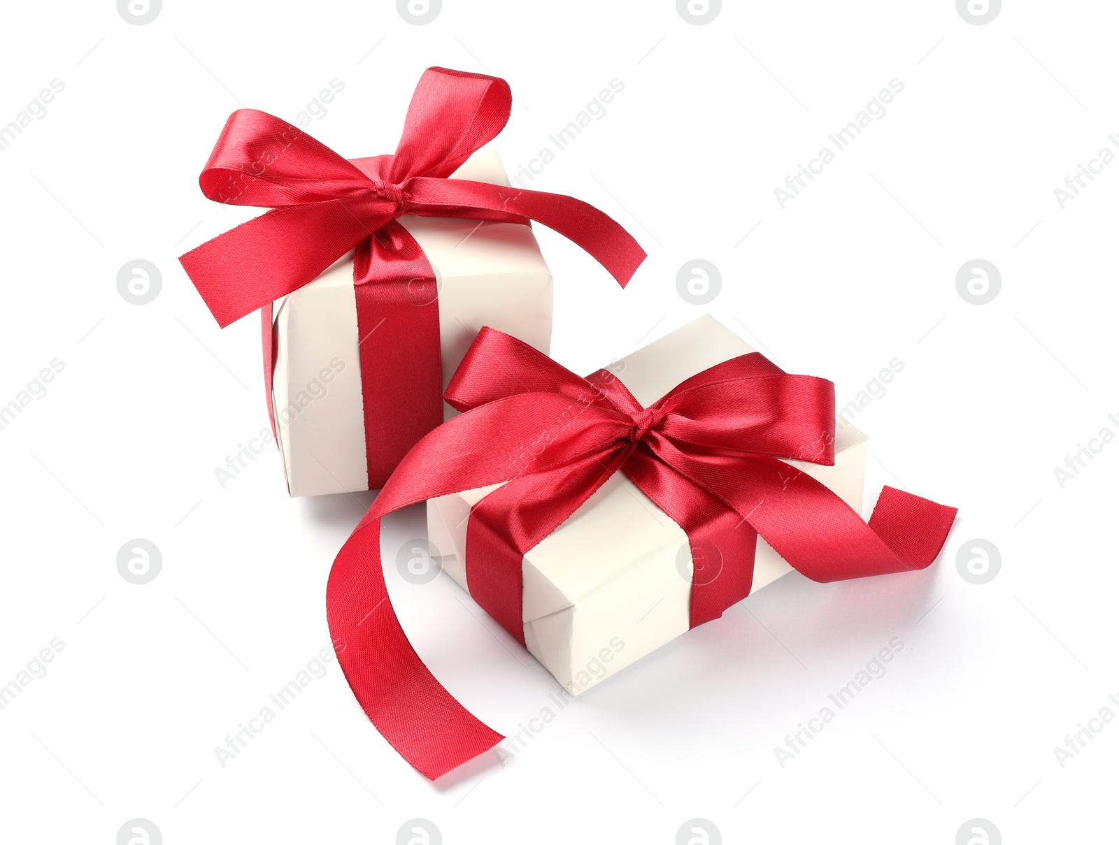 Photo of Beautiful gift boxes with red bows isolated on white