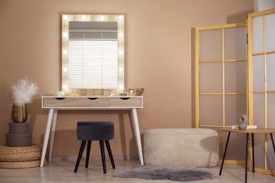 Photo of Stylish dressing table with mirror in room