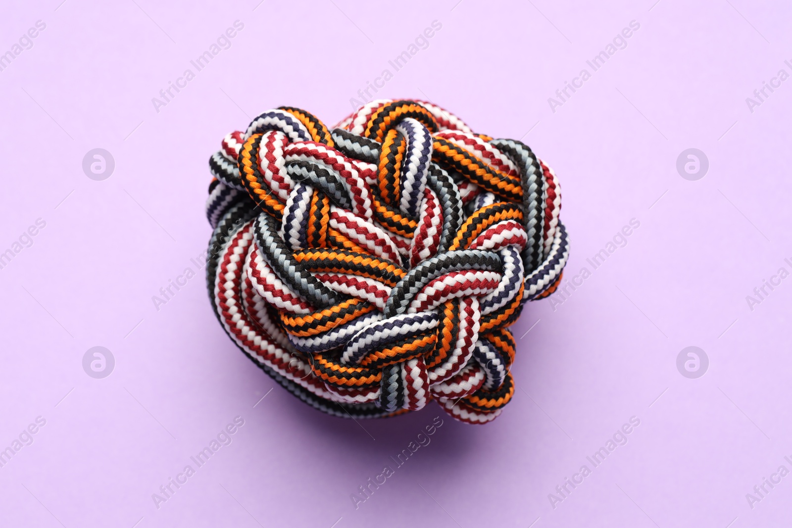 Photo of Colorful ropes tied in knot on violet background, top view. Unity concept