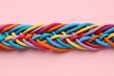 Photo of Colorful ropes tied together on pink background, top view. Unity concept