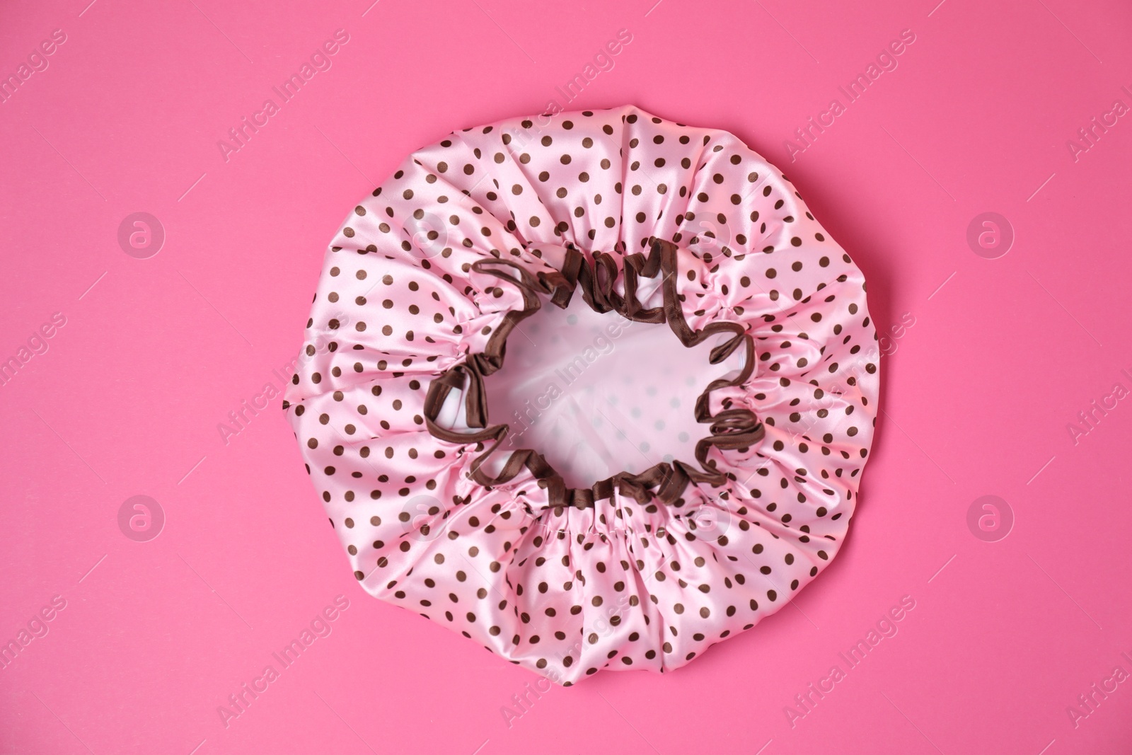 Photo of One shower cap on pink background, top view