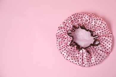 Photo of One shower cap on pink background, top view. Space for text