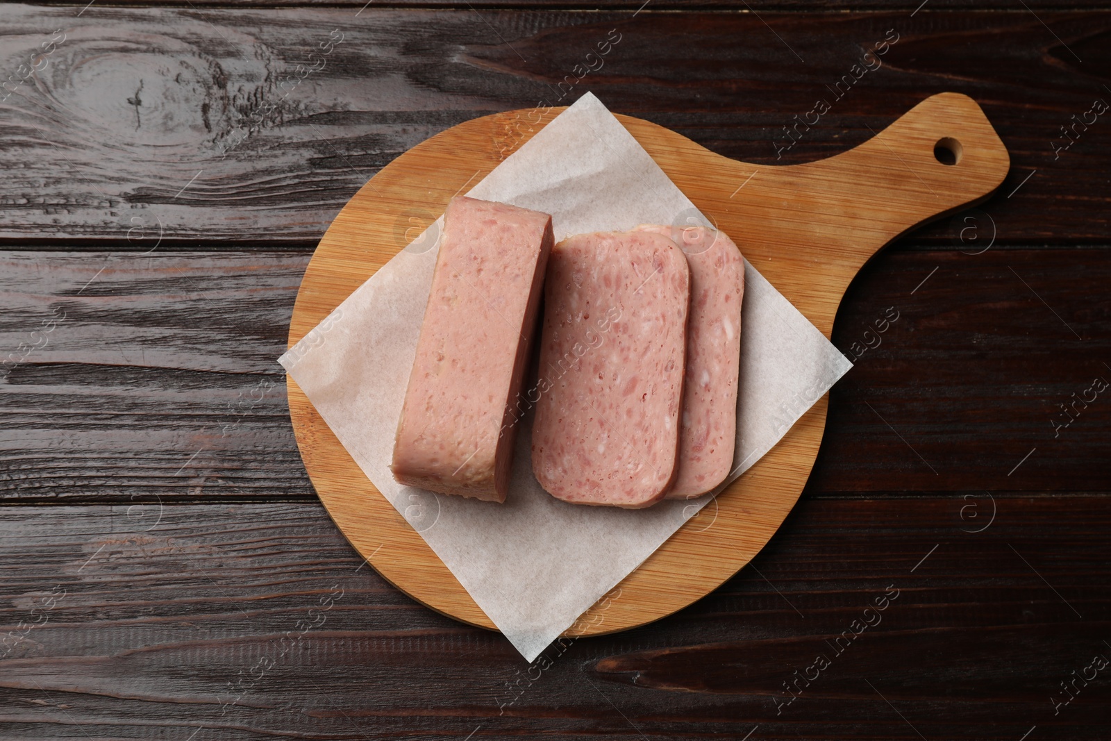 Photo of Tasty canned meat on wooden table, top view