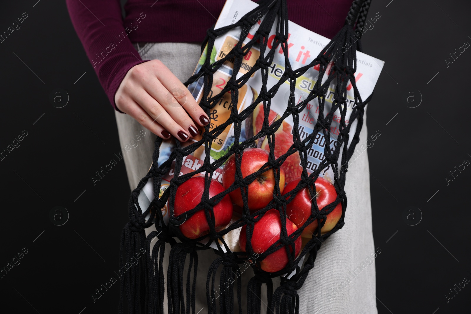 Photo of Teenage girl with handmade macrame bag on black background, closeup