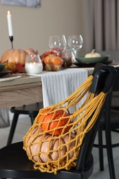 Photo of Macrame bag with products on chair indoors