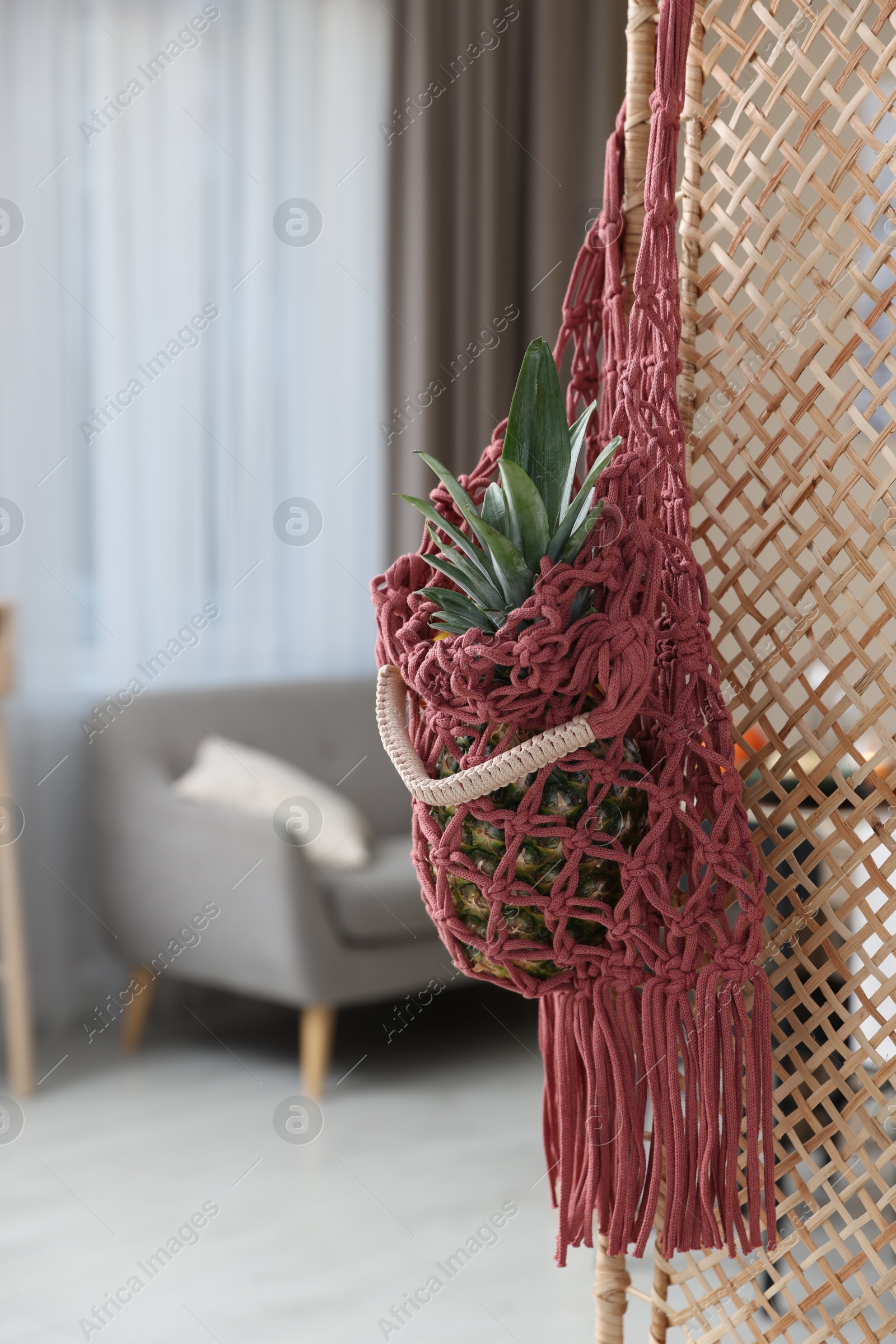 Photo of Macrame bag with fruits on folding screen indoors