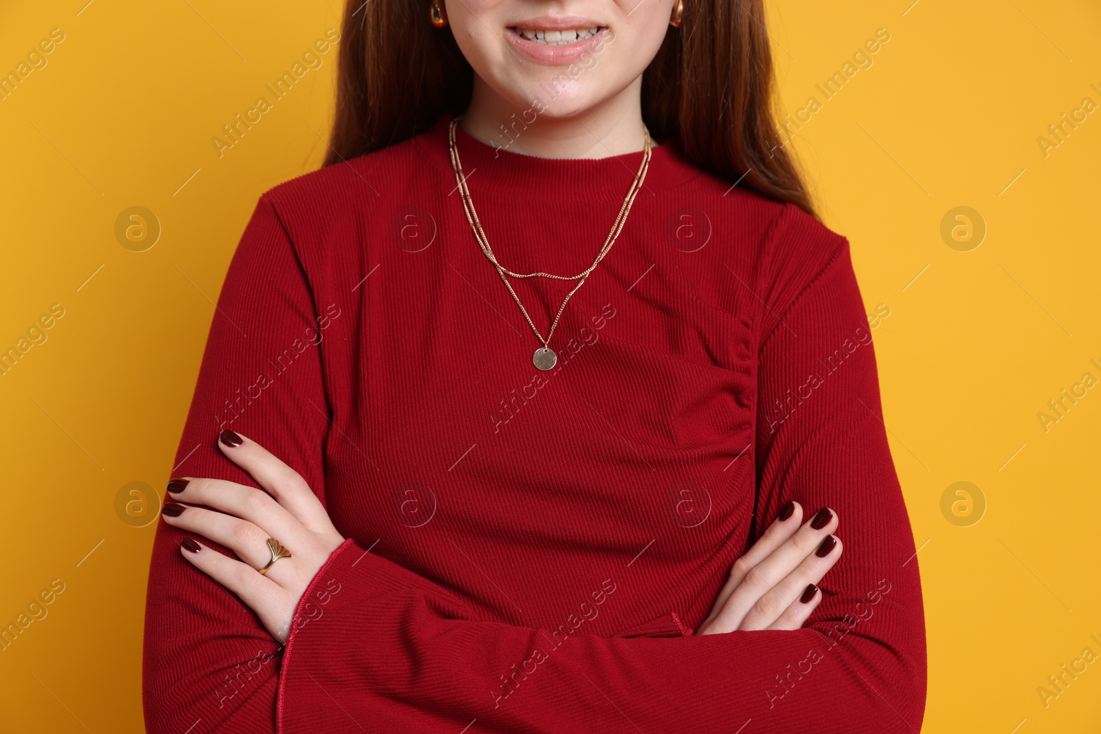 Photo of Teenage girl wearing stylish jewellery on yellow background, closeup