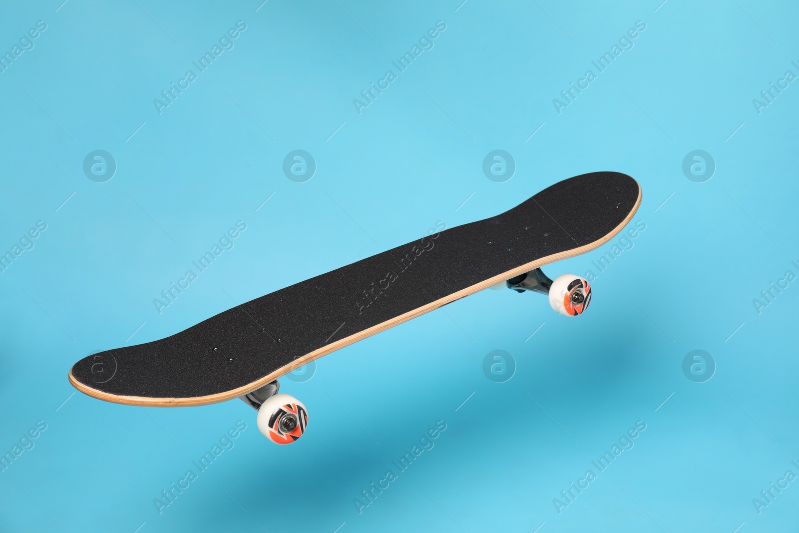 Photo of One skateboard on light blue background. Sports equipment