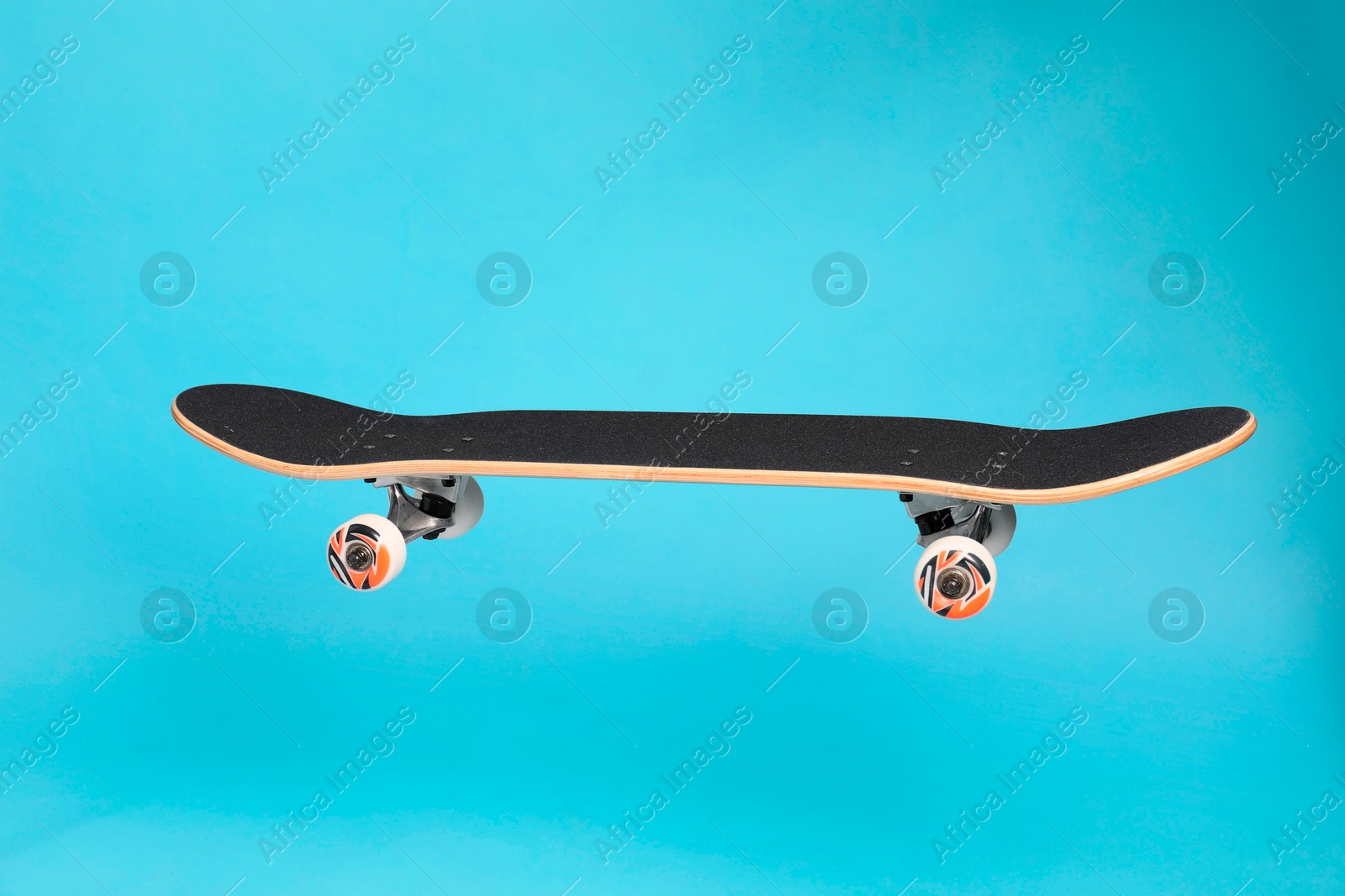 Photo of One skateboard on light blue background. Sports equipment