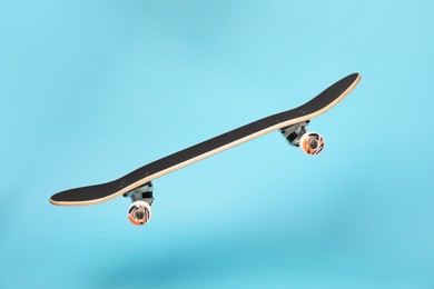 Photo of One skateboard on light blue background. Sports equipment