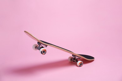 Photo of One skateboard on pink background. Sports equipment