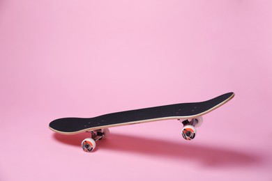 Photo of One skateboard on pink background. Sports equipment