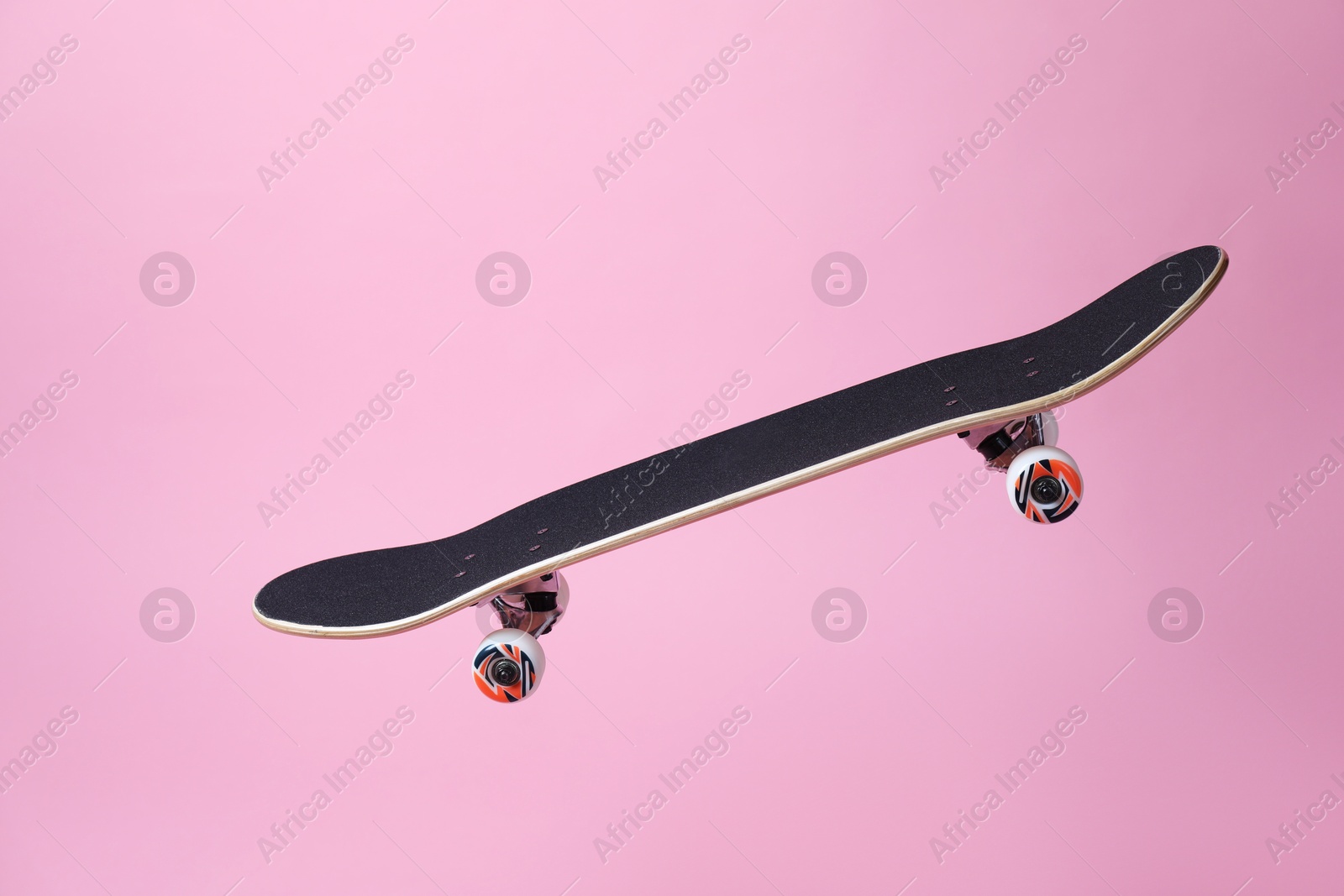 Photo of One skateboard on pink background. Sports equipment