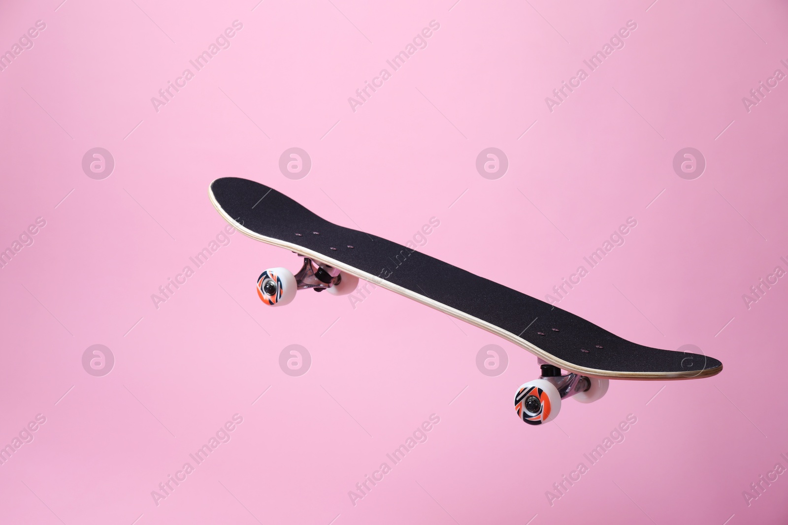 Photo of One skateboard on pink background. Sports equipment