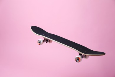 Photo of One skateboard on pink background. Sports equipment