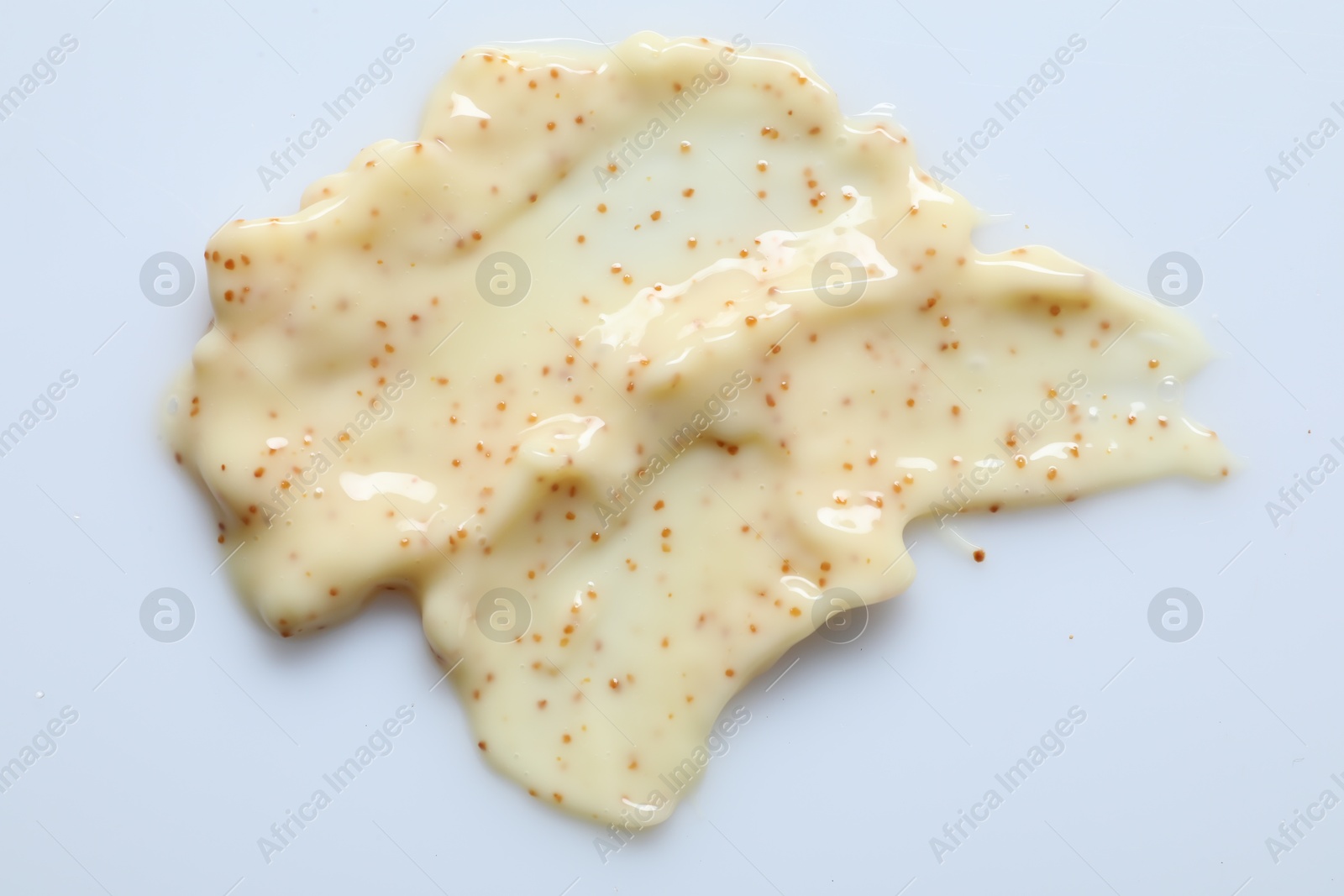 Photo of Smears of body scrub on light background, top view