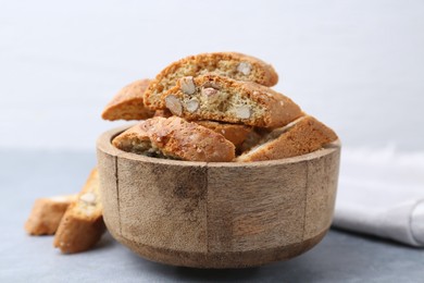 Photo of Traditional Italian almond biscuits (Cantucci) in bowl on grey table, closeup