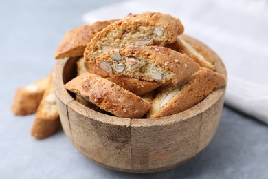 Photo of Traditional Italian almond biscuits (Cantucci) in bowl on grey table, closeup