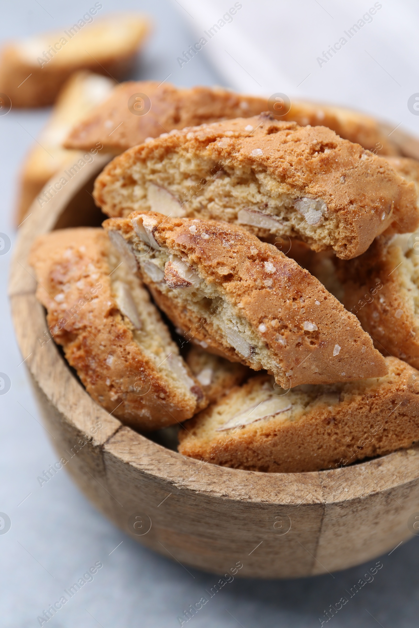 Photo of Traditional Italian almond biscuits (Cantucci) in bowl on grey table, closeup