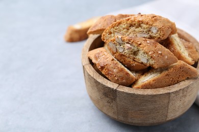 Photo of Traditional Italian almond biscuits (Cantucci) in bowl on grey table, closeup. Space for text