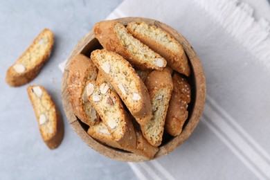 Photo of Traditional Italian almond biscuits (Cantucci) in bowl on grey table, top view