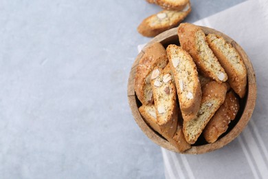 Photo of Traditional Italian almond biscuits (Cantucci) in bowl on grey table, top view. Space for text