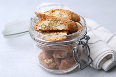 Photo of Traditional Italian almond biscuits (Cantucci) in jar on light table, closeup