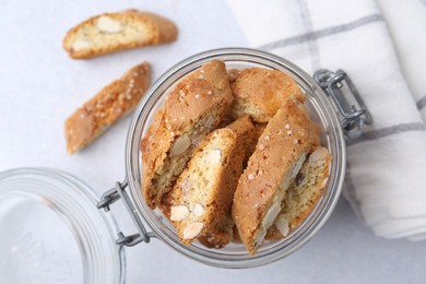 Photo of Traditional Italian almond biscuits (Cantucci) in jar on light table, top view