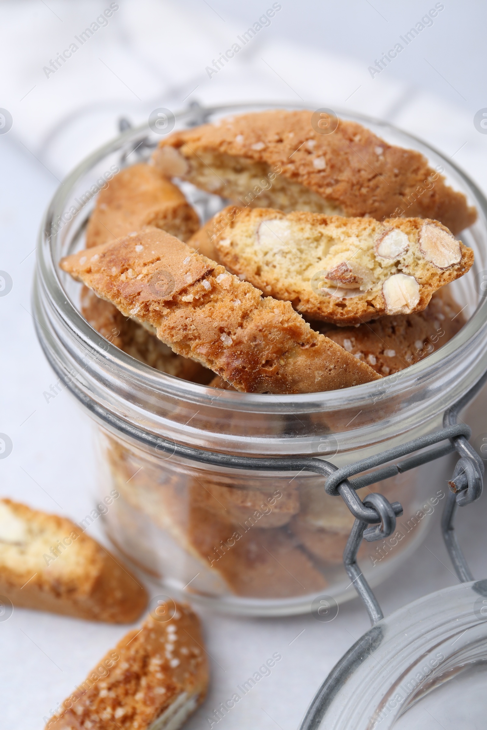 Photo of Traditional Italian almond biscuits (Cantucci) in jar on light table, closeup